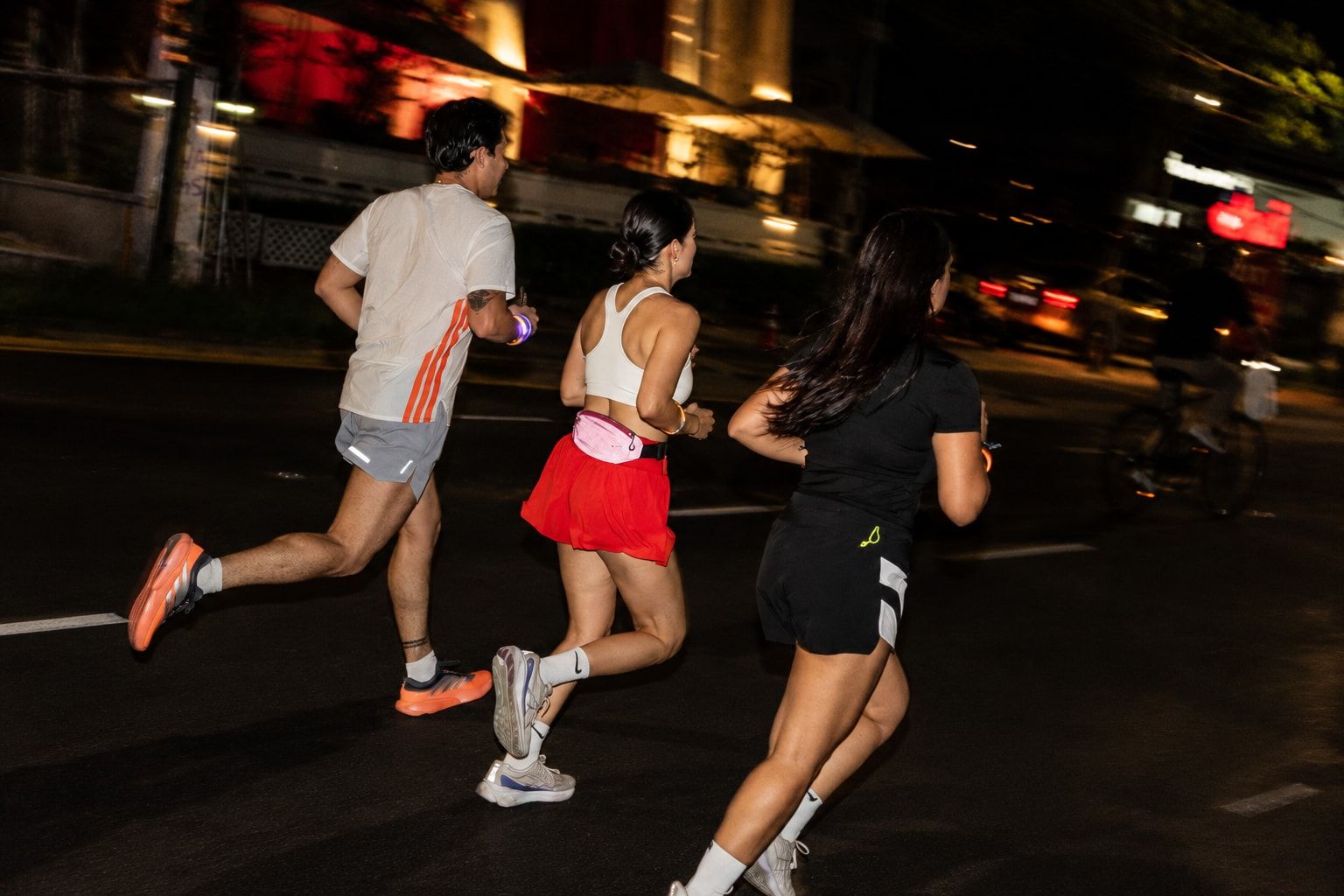 Group of runners moving together down the lit avenue